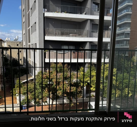 סורגים ישרים ממתכת שהותקנו מחוץ לחלון הזזה בדירה